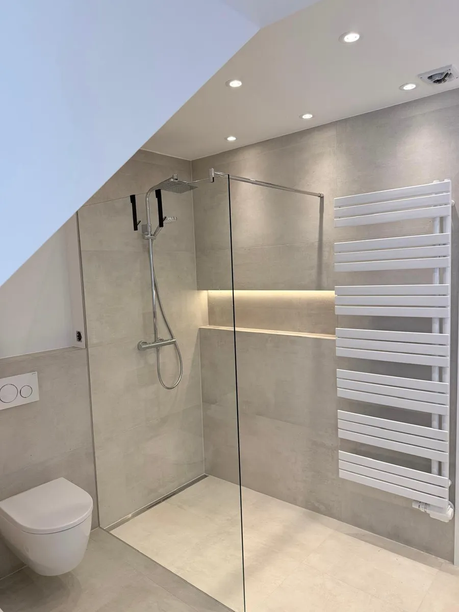 Bodengleiche Dusche mit Glaswand, beleuchteter Nische, Handtuchheizkörper und wandhängendem WC