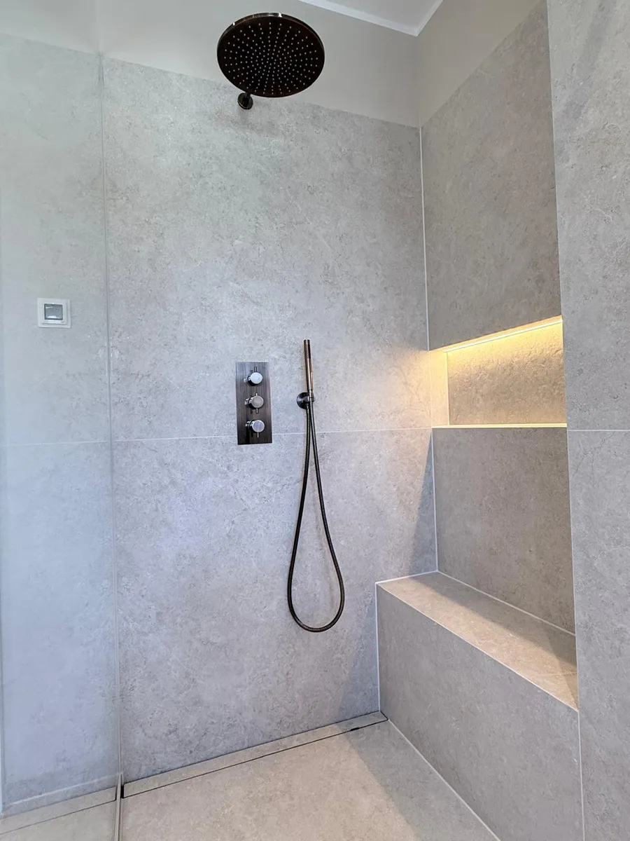 Dusche mit gemauerter Sitzbank und Regenbrause
