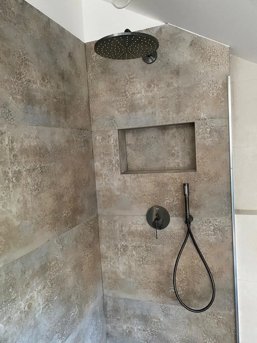 Dusche mit schwarzer Regenbrause und Wandnische