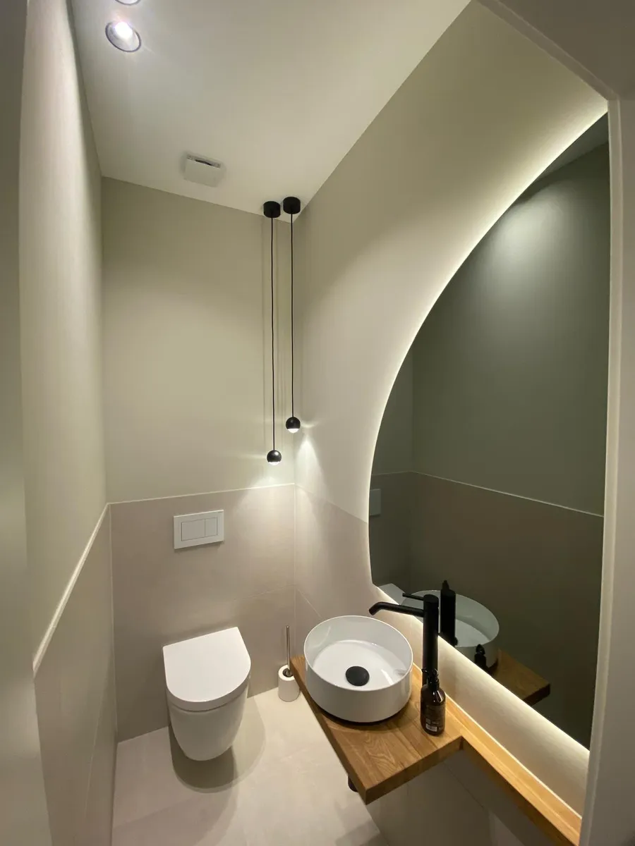 Gäste-WC mit geschwungener Wand, Aufsatzbecken und wandhängendem WC