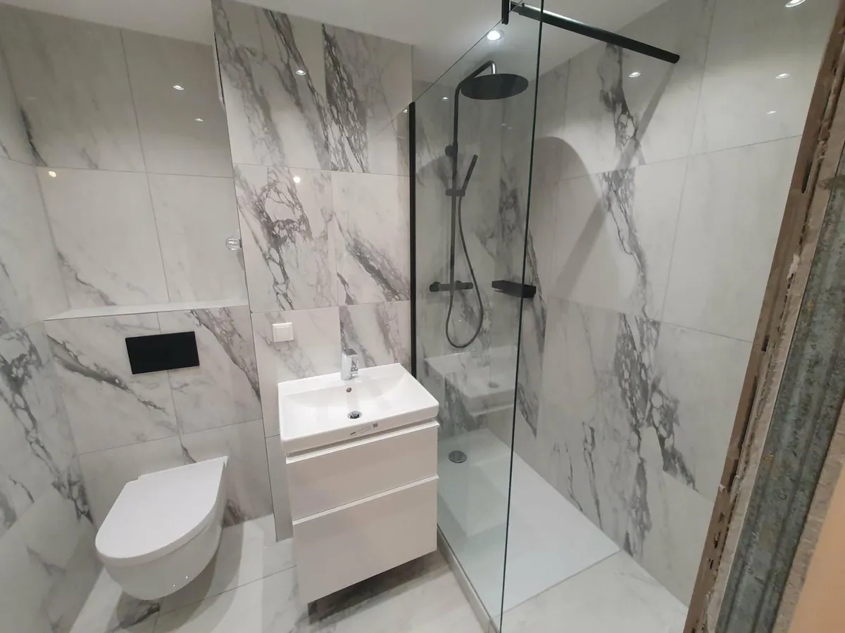 Bad in Marmoroptik mit Dusche und Waschtisch