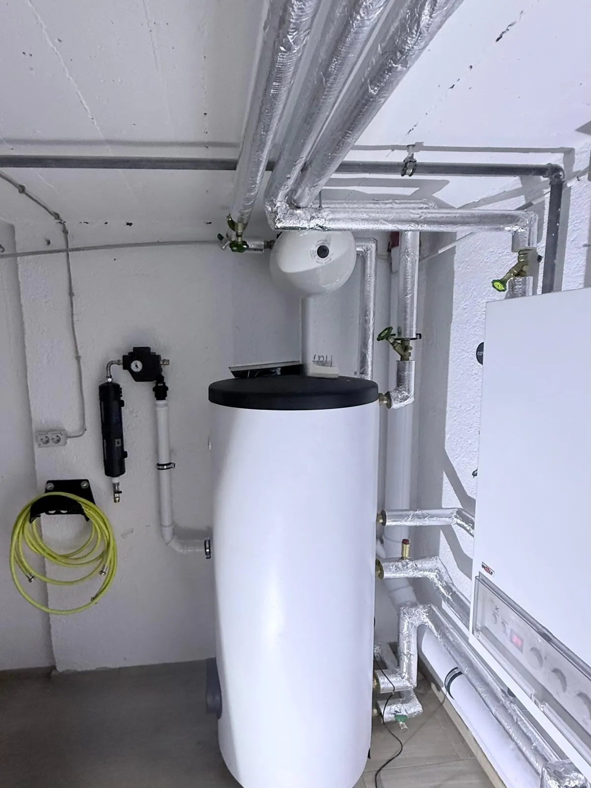 Heizungsraum mit Gas-Brennwertgerät, Abgasleitung und Warmwasserspeicher